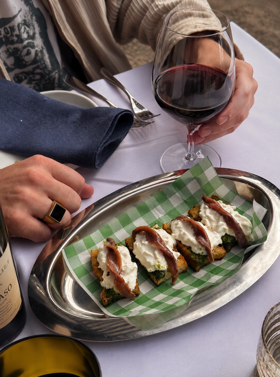 Rotwein und kleine Gerichte auf einem gedeckten Tisch