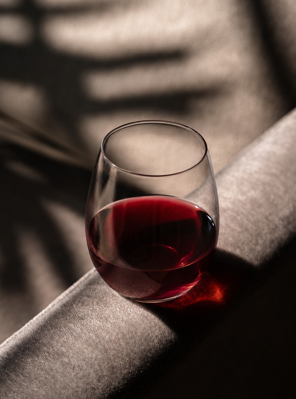 Rotwein im Glas auf fließendem Stoff